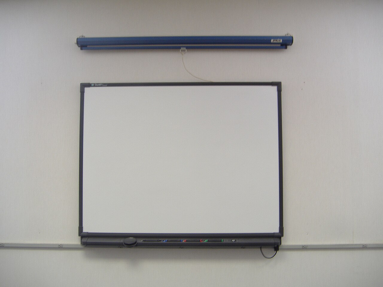 A large wall-mounted interactive SMART board installed on a classroom wall.