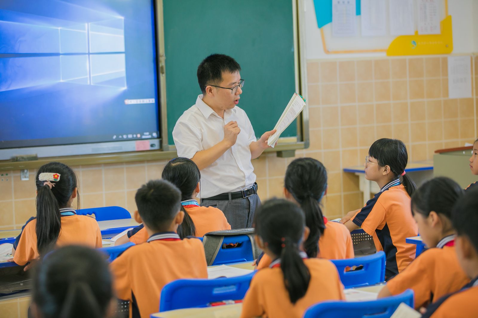 A teacher instructing attentive students during a school classroom activity.