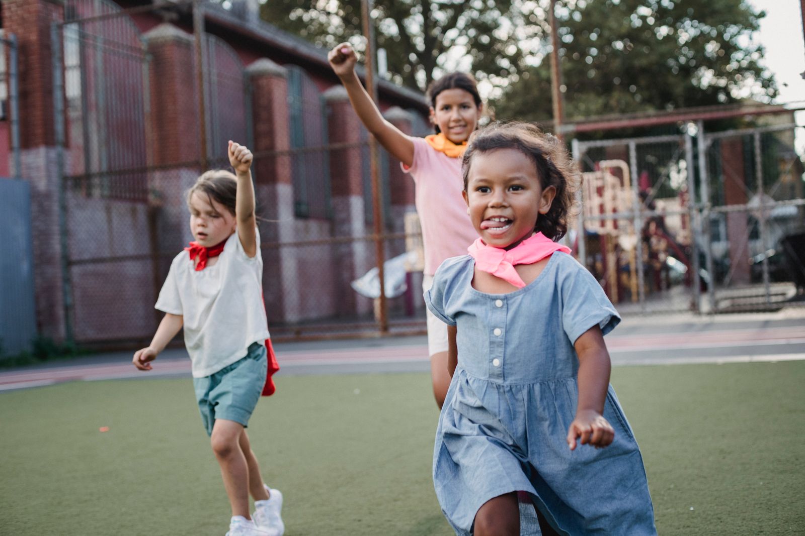 Girls running on a school playground during a playful sports-day race.