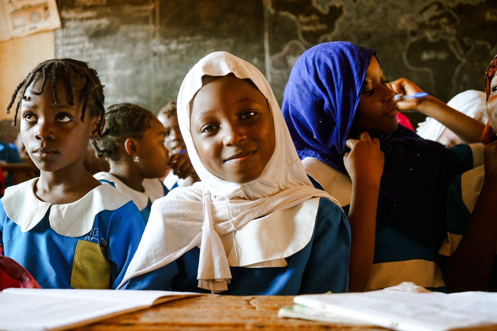 A diverse group of students in school uniforms working together in a classroom.
